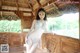 A woman in a bikini posing on a wooden bench.