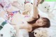 A woman laying on a bed with stuffed animals.