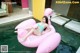 A woman in a bikini laying on an inflatable flamingo.