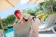 A woman in a black bikini sitting on a lounge chair by a pool.