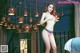 A woman in a pink bikini posing on a balcony.