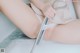 A woman is sitting in a bathtub with a shower head.